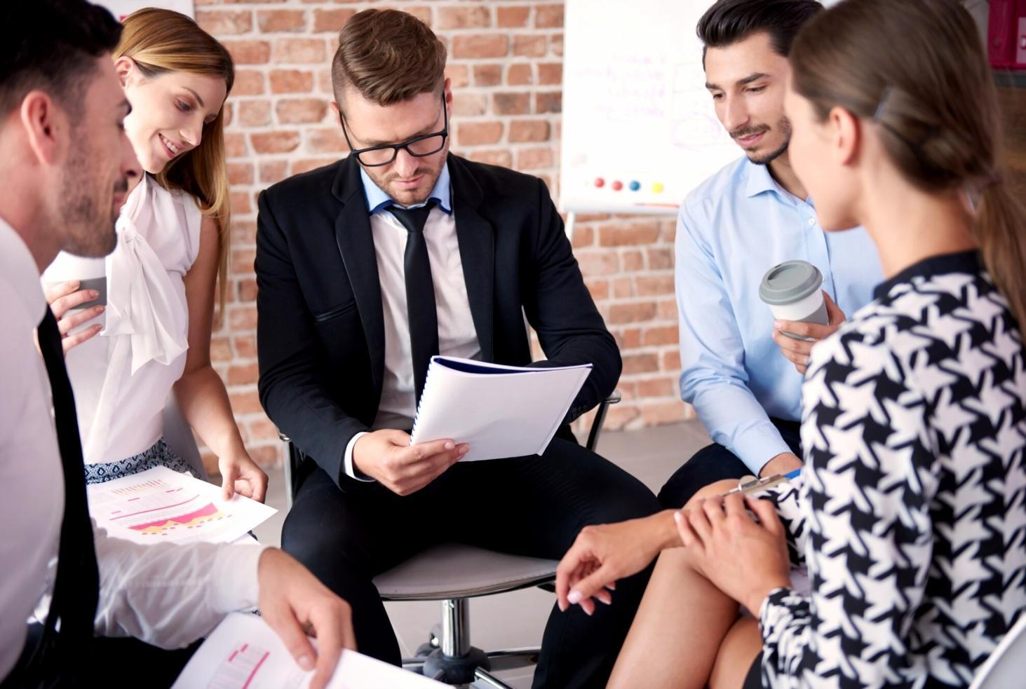 Echipa dorvaxenilo lucrând împreună la materiale educaționale despre planificare financiară